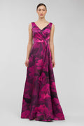 Woman wearing a vibrant pink and purple floral patterned dress on a light gray background